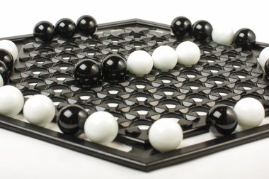 Racism concept black vs white marbles on Abalone game board clipart