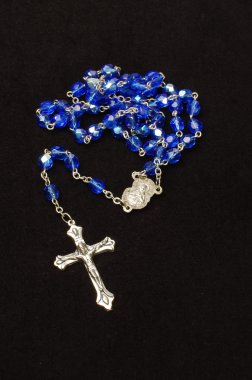 Blue glass rosary isolated on the dark background clipart