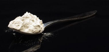 Siyah arka plan üzerine izole un dolu kaşık