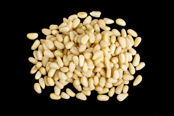 Pile of pine nuts isolated on the black background — Stock Photo, Image