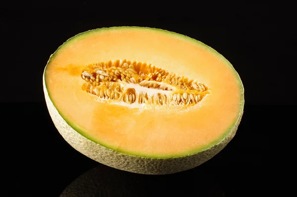 Cantaloupe melon fruit with reflection isolated on the black background — Stock Photo, Image
