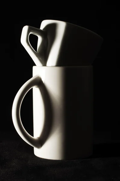 Küçük kahve fincanı karanlıkta daha büyük çay Kupası — Stok fotoğraf