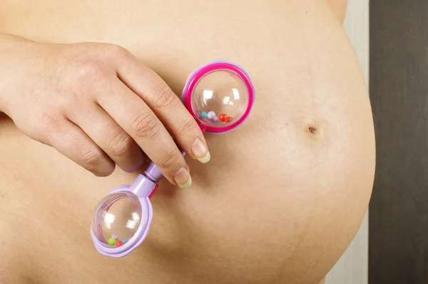 Pregnant woman holding rattle toy — Stock Photo, Image