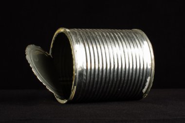 Metal can with open lid lying on the black background clipart