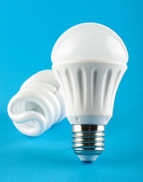 Lámpara led delante de la lámpara CFL sobre fondo azul —  Fotos de Stock