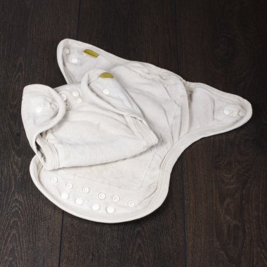 Koyu ahşap arka plan üzerinde izole doğal yeniden kullanılabilir bez bebek bezi