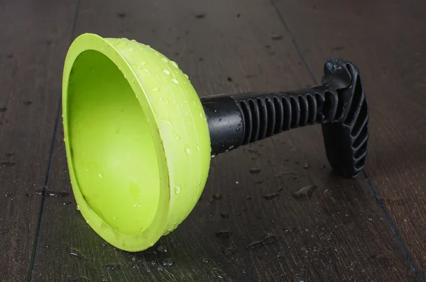 Rubber cup plunger isolated on the black wooden background — Stock Photo, Image