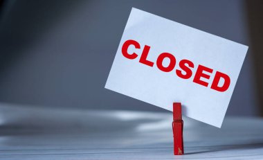 Masada kıyafet iğnesi olan yapışkan notu hatırlat. Coronavirus tarafından kapatılmış, üzerinde yazı olan yapışkan bir not.