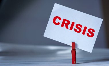 Masada kıyafet iğnesi olan yapışkan notu hatırlat. Üzerinde Kriz Yazısı olan yapışkan bir not. Dünyada iş çöküşü