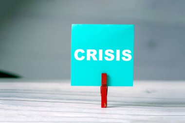 Masada kıyafet iğnesi olan yapışkan notu hatırlat. Üzerinde Kriz Yazısı olan yapışkan bir not. Dünyada iş çöküşü