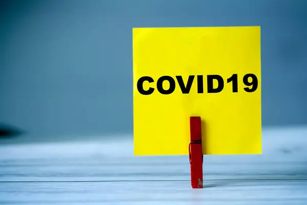 テーブルの上に服ピンで付箋を思い出してください Covid19という言葉で付箋 コロナウイルスのパンデミックの概念 — ストック写真