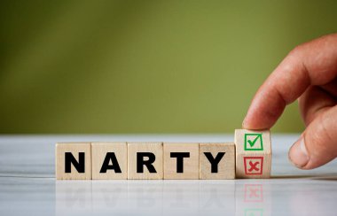 El ahşap küpü çevirir ve yeşil pozitif tik kutusu ve kırmızı reddetme X işaretli kutusuyla polonyalı kelime NARTY 'yi (İngiliz kayakları) değiştirir.