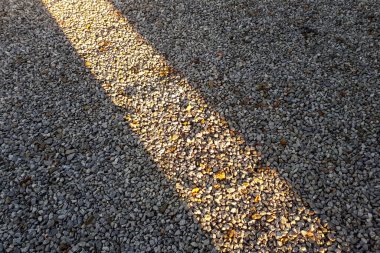 Doğal taş çakıl taşı malzeme dokusu arka plan. Taş zemin, karanlık çakıl taşları güneş ışınlı taş dokular