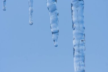 Yakın çekim buz saçağı arkaplanı. Çatıdan sarkan buz saçakları. Soğuk kış havası, kış mevsimi konsepti