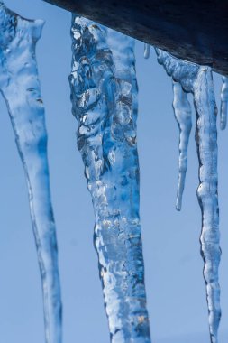 Yakın çekim buz saçağı arkaplanı. Çatıdan sarkan buz saçakları. Soğuk kış havası, kış mevsimi konsepti