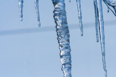 Yakın çekim buz saçağı arkaplanı. Çatıdan sarkan buz saçakları. Soğuk kış havası, kış mevsimi konsepti