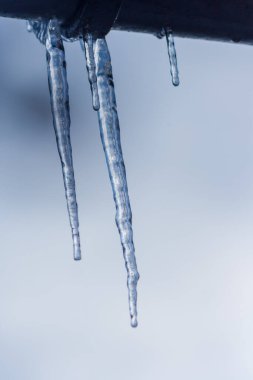 Yakın çekim buz saçağı arkaplanı. Çatıdan sarkan buz saçakları. Soğuk kış havası, kış mevsimi konsepti