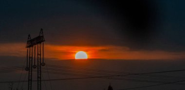 Gün batımı ve gökyüzünde inanılmaz bulutlar. Turuncu güneş kalkanı. Turuncu gökyüzünde gümüş astar ve bulutla güçlü bir gün doğumu