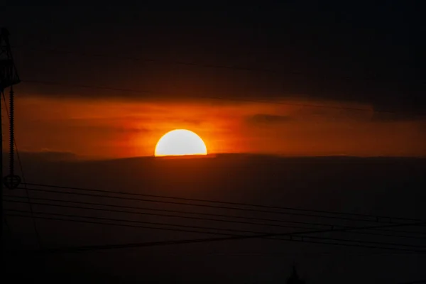空に沈む夕日と素晴らしい雲 オレンジの太陽の盾 オレンジ色の空に銀の裏地と雲と強い日の出 — ストック写真
