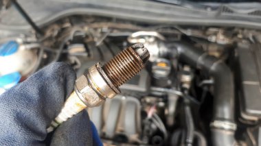 Motor arka planında eski bir araba mumu insan elinde. Tamirci konsepti. Araba tamiri 