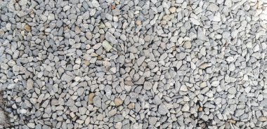 Çakıl yolu dokusu. Küçük gri çakıl taşı desenli. Taş zemin arka planı.