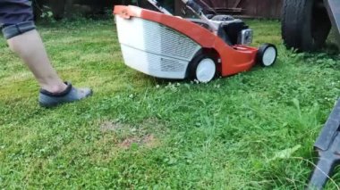 Çim kısalıyor. Bahçe işleri konsepti. Çim biçme makinesiyle çimleri biçiyorum.. 