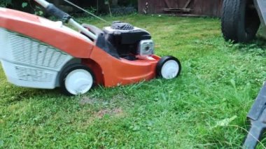 Çim kısalıyor. Bahçe işleri konsepti. Çim biçme makinesiyle çimleri biçiyorum.. 