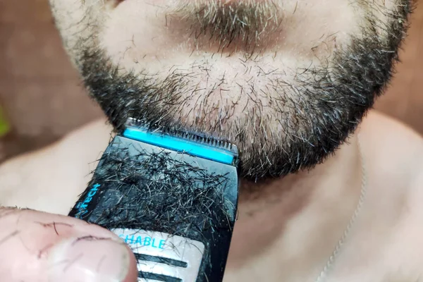 男人用电动剃须刀刮胡子 英俊的小胡子男人用修整器修剪胡子 — 图库照片