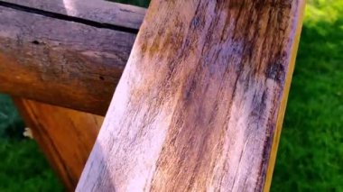 Tahta tahtalara koruyucu cila sürüyorum. Yakın plan. Fırçayla ahşap boya.