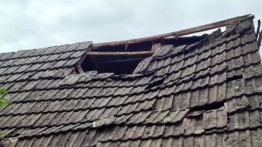 Büyük bir deliği olan eski kiremitli çatı. Kırık çatı