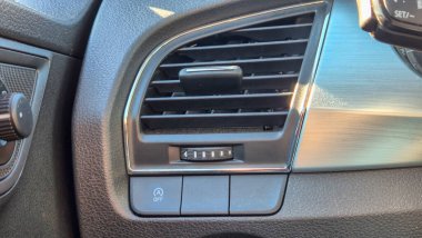 Hava kontrol menfezini gösteren ve modern tasarım ve işlevselliği vurgulayan bir arabanın ayrıntılı görünümü. Otomotiv yazıları için ideal.