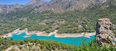 Bereketli yeşil ormanlar ve dağlarla çevrili turkuaz bir göl soluk kesici. Manzarada açık hava aktiviteleri için mükemmel sakin bir doğal ortam sergileniyor..