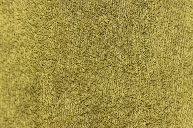 Yumuşak desenli yeşil tonda yumuşak bir havlunun yakın plan görüntüsü. Karmaşık lifler, refah veya rahatlama temalarında arka plan için ideal derinlik yaratır..