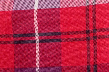 Karmaşık ekose desenli canlı kırmızı bir kumaşın yakın çekim görüntüsü. Tasarım projeleri için ideal tekstil veya arkaplan uygulamaları.
