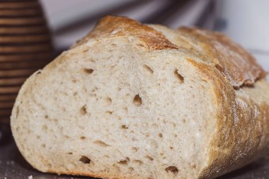 Kırsal bir mutfak masasında sergilenen taze pişmiş ekmek. Zanaatkar kabuğu altın kahverengidir ama içi yumuşak ve kabarık kalır. Yemek fotoğrafçılığı ve aşçılık projeleri için ideal..