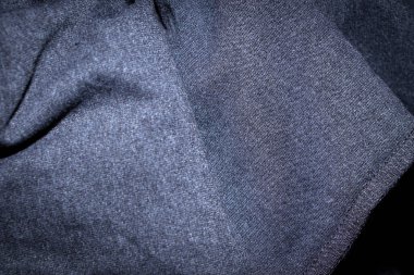 Koyu renk kumaş kaplamalı, karmaşık dokuma desenlerinin yakın çekimi. Moda tasarımı veya imalat uygulamaları için ideal bir arkaplan.