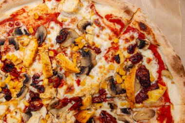 Tavuk mantarı, mısır ve altın kabuklu güneşte kurutulmuş domatesle kaplı leziz pizza. Toplantılarda ya da özel günlerde paylaşmak için mükemmel..