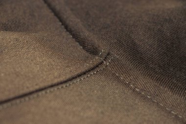 Kalıplı kahverengi kumaş kaplamalı ayrıntılı dikişler. Moda tekstil tasarımı veya malzeme kalitesini vurgulayan döşeme uygulamaları için ideal.