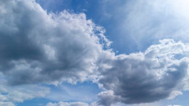Pofuduk bulutların parlak mavi gökyüzüne dağılmış manzarası huzurlu bir atmosfer yaratıyor. Doğa havası ve atmosferik kavramlar için mükemmel.