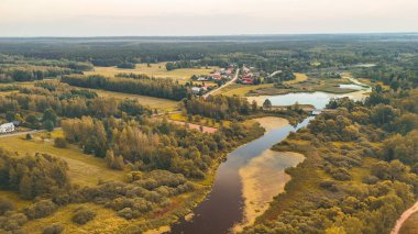 Dolambaçlı bir nehir yeşilliği ve gün batımında küçük bir kırsal yerleşim olan sakin bir ortamın havadan görünüşü doğa meraklıları için mükemmel..