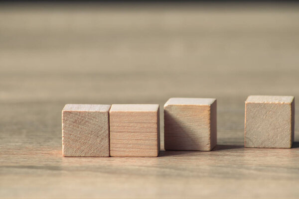 Close-up of wooden cubes arranged on a table showcasing simplicity and creativity. Ideal for educational business or artistic concepts in natural light.