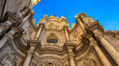 Valencia İspanya - 13 Temmuz 2025: Valencia 'da mavi gökyüzüne karşı karmaşık oymalarla yapılmış tarihi bir binanın dekoratif mimari ayrıntılarına yakından bakmak.