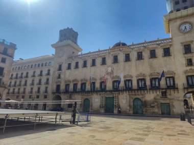 Alicante İspanya - 12 Temmuz 2025: Alicante 'deki tarihi belediye binasının görüntüsü gün ışığında eşsiz mimari ve canlı bayraklar sergiliyor.