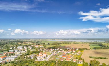 Mikolajki Polonya - 29 Eylül 2024: Mikolajki 'nin panoramik hava manzarası açık mavi gökyüzü altında canlı yeşil alanlar ve dingin göller sergiliyor.
