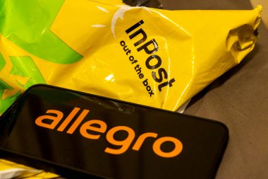 Varşova Polonya - 8 Ekim 2025: Modern dağıtım hizmetleri ve e-ticareti vurgulayan bir cep telefonunda turuncu Allegro logosu sergilenen bir Inpost paketinin yakın çekimi.