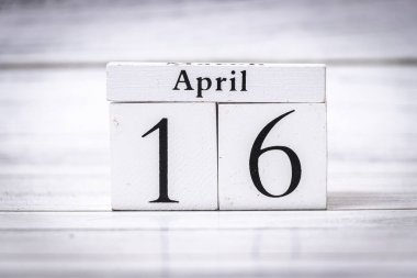 Zaman yönetimi ve organizasyonu simgeleyen 16 Nisan tarihli ahşap bir takvim. Planlama programları ve verimlilik çevresindeki temalar için mükemmel.