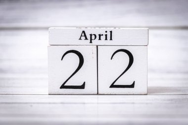 22 Nisan tarihini gösteren tahta blok takvimi. Temiz tasarım, bahar hatıraları ve olayları için ideal basitlik ve organizasyonu vurgular..