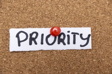 Kırmızı bir raptiyeyle mantar panoya tutturulmuş 