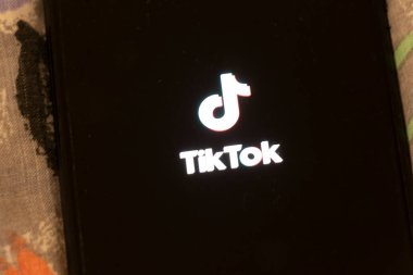 Varşova Polonya - 3 Kasım 2025: Modern kültürde sosyal medya uygulamalarının popülaritesini gösteren TikTok logosunu gösteren cep telefonu ekranının yakın çekimi.