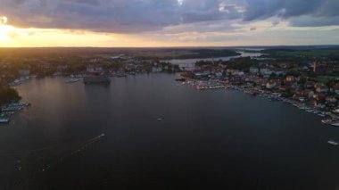 Günbatımında Mikolajki 'ye 4K panoramik hava manzarası - Masurian bölgesinin başkenti. Mikolajskie gölü gün batımı
